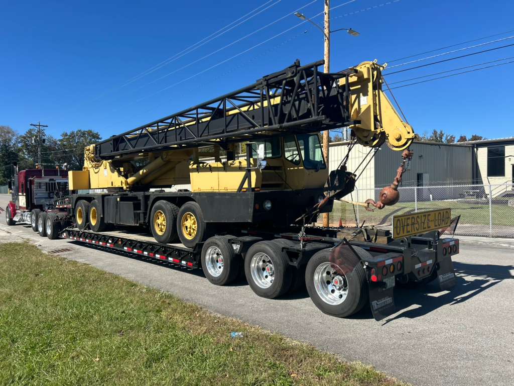 Large yellow crane on oversize load trailer
